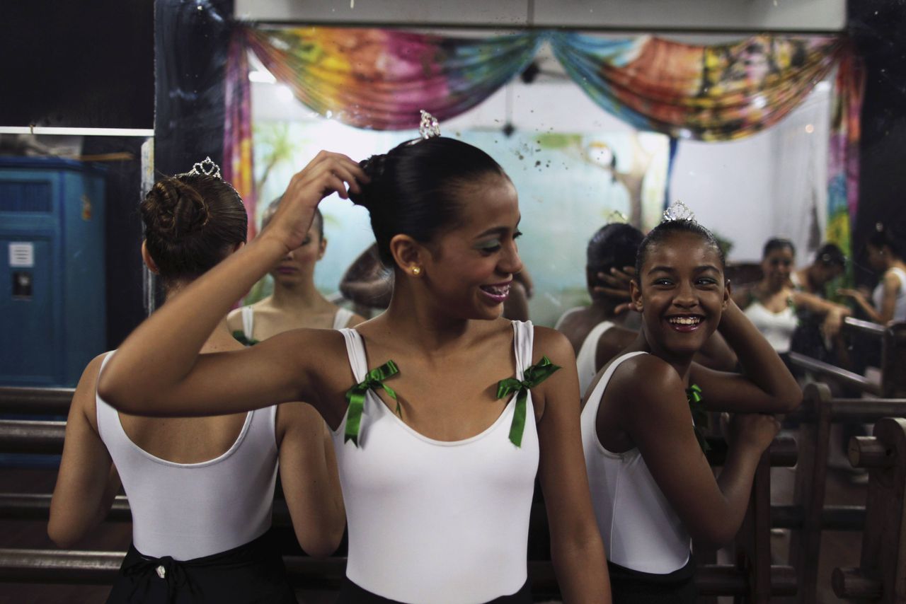 Girls laugh as they wait for their ballet class to start at the 'Ballet Santa Teresa' academy in Rio de Janeiro August 13, 2012.'Ballet Santa Teresa', a non-governmental organization (NGO) gives children who live in areas with social risk, some suffering domestic violence, free ballet classes and other activities as a part of socio-cultural integration project. Picture taken August 13, 2012. REUTERS/Pilar Olivares (BRAZIL - Tags: SOCIETY)