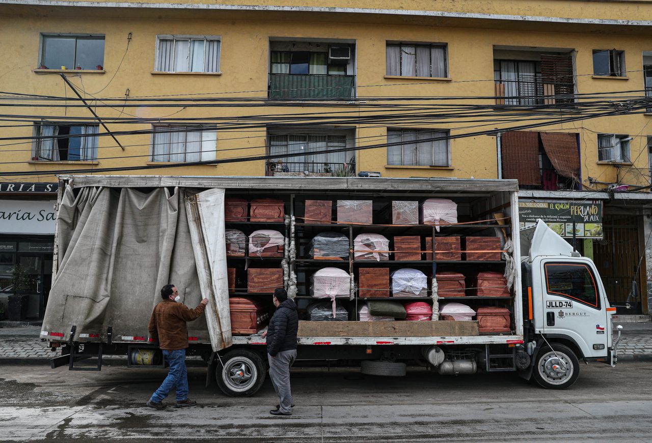 Werknemers van een uitvaartbedrijf leveren grafkisten af in hoofdstad Santiago, Chili.