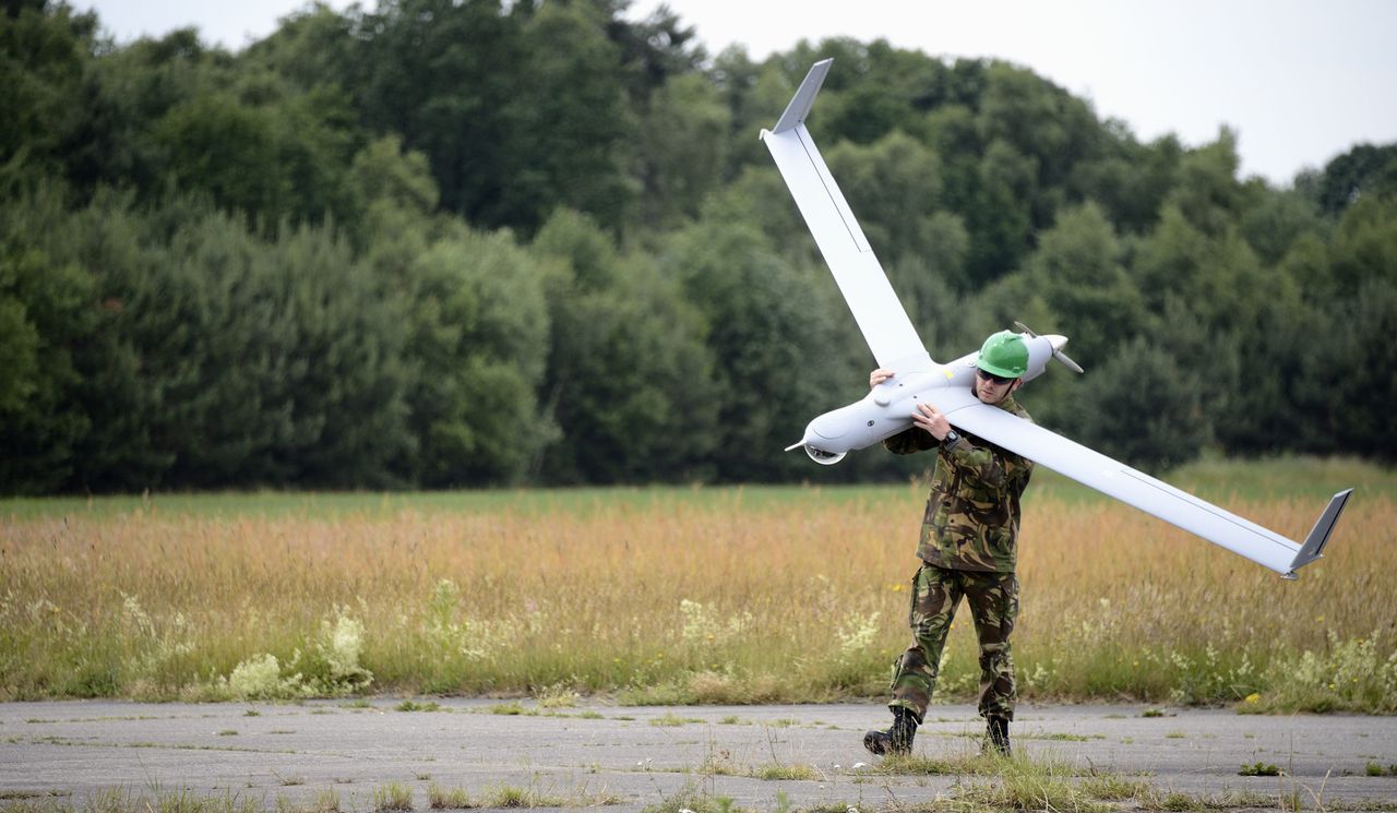 Een medewerker van Defensie loopt met een drone, een onbemand vliegtuigje dat vanaf 5 kilometer hoogte foto's of video's van de grond kan maken en meteen naar een grondstation kan sturen. Defensie heeft 12 drones van het type ScanEagle.
