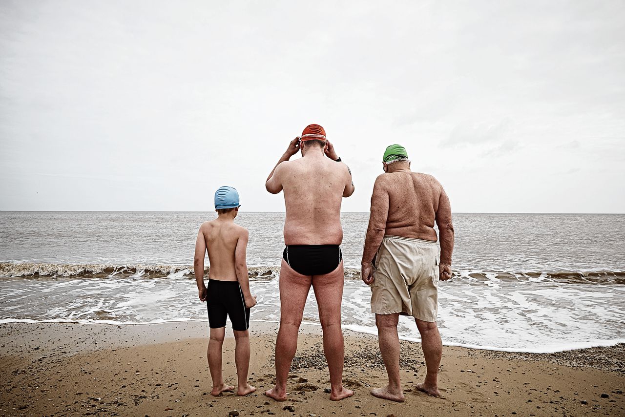 Zoon, vader en grootvader gaan zwemmen in zee.