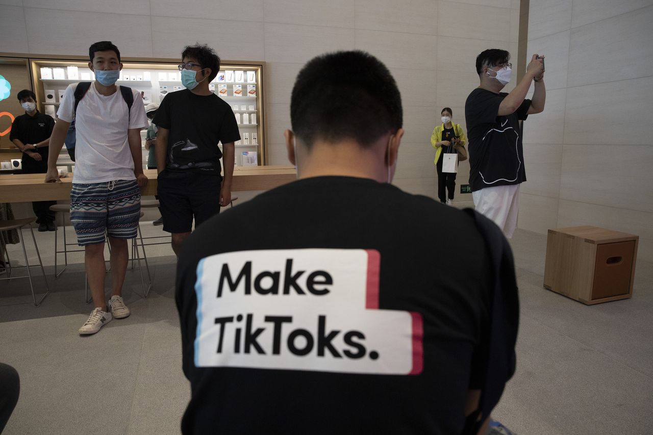 Man met een TikTok-promotieshirt aan in een winkel van Apple in Beijing.