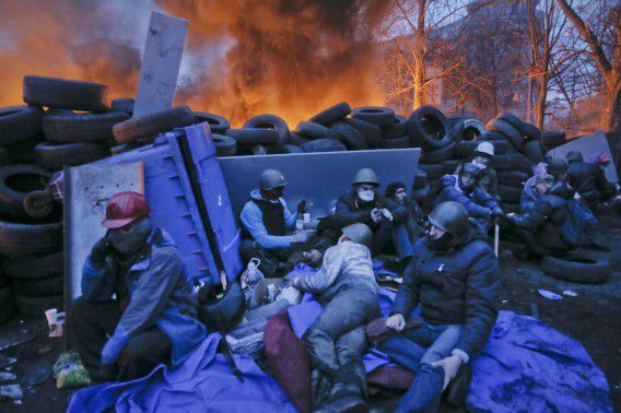 Activisten verstoppen zich achter een barricade in de buurt van het Onafhankelijkheidsplein in Kiev.