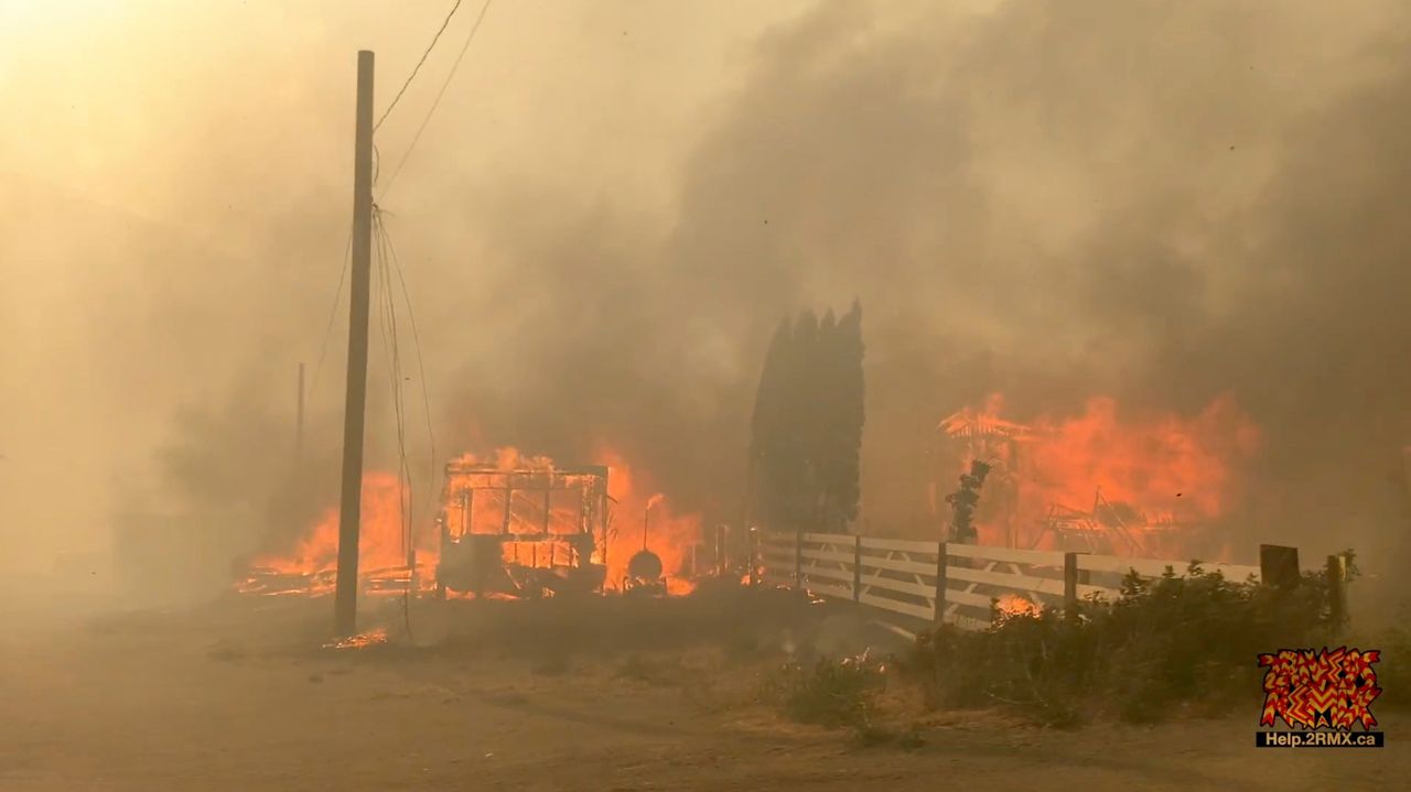 Een natuurbrand woedt in het west-Canadese dorp Lytton, op beelden van een vluchtende inwoner van het dorp, dat donderdag grotendeels in de as is gelegd tijdens een extreme hittegolf in de regio.