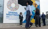 Passanten bij het hoofdkantoor van het IMF in Washington, waar tot en met 18 april de voorjaarsvergadering van het Fonds plaatsvindt. 