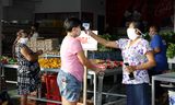 Surinamers doen woensdag inkopen in een supermarkt in Paramaribo, voorafgaand aan de lockdown die donderdagavond is ingegaan.