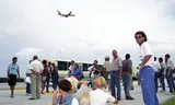 07-07-1994 Orlando, bommelding op vlucht van Orlando naar Dallas        Spelers met partners, officials en media op de landingsbaan, Danny Blind In de zomer van 1994 leidt een grap van sportjournalist Lex Muller van het Algemeen Dagblad ertoe dat het Nederlands elftal op het vliegveld van het Amerikaanse Orlando een vertraging van meer dan vijf uur oploopt. Muller zegt in het vliegtuig dat de koffer van een fotograaf een bom bevat. Als hij dat nog tweemaal herhaalt, waarschuwt de stewardess de gezagvoerder en de politie. Die neemt geen halve maatregelen. De verbouwereerde Muller wordt gearresteerd en aan de FBI overgeleverd. Alle 181 inzittenden, onder wie de complete Oranje-selectie, moeten het toestel verlaten en worden een voor een gecontroleerd. Vijf uur later pas kan het Nederlands elftal vertrekken naar Dallas, waar het in de kwartfinale van het WK voetbal Brazilie ontmoet en prompt verliest. Muller wordt een nationale kop van Jut en het AD zegt over een hele pagina sorry tegen Oranje. ANP / Hollandse Hoogte /  copyright © Foto Leo Vogelzang VOF