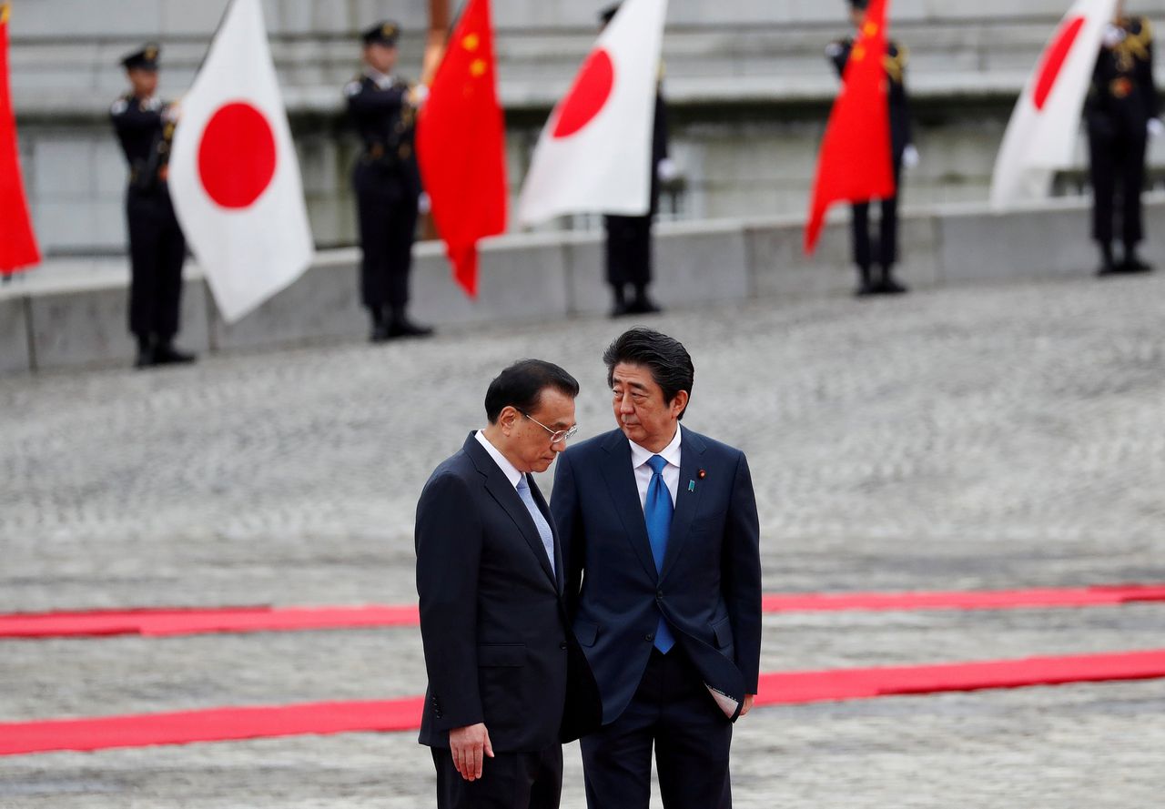 De Chinese premier Li Keqiang en de Japanse minister-president Shinzo Abe voor het overleg.