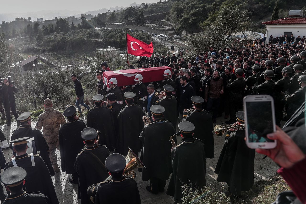 Leden van de militaire politie van de Turkse strijdkrachten dragen de kist van de Turkse soldaat Mohammed Ali Özer, die omkwam bij een luchtaanval in de Syrische stad Idlib, tijdens zijn begrafenisceremonie in het Zuid-Turkse dorp Gülderen.
