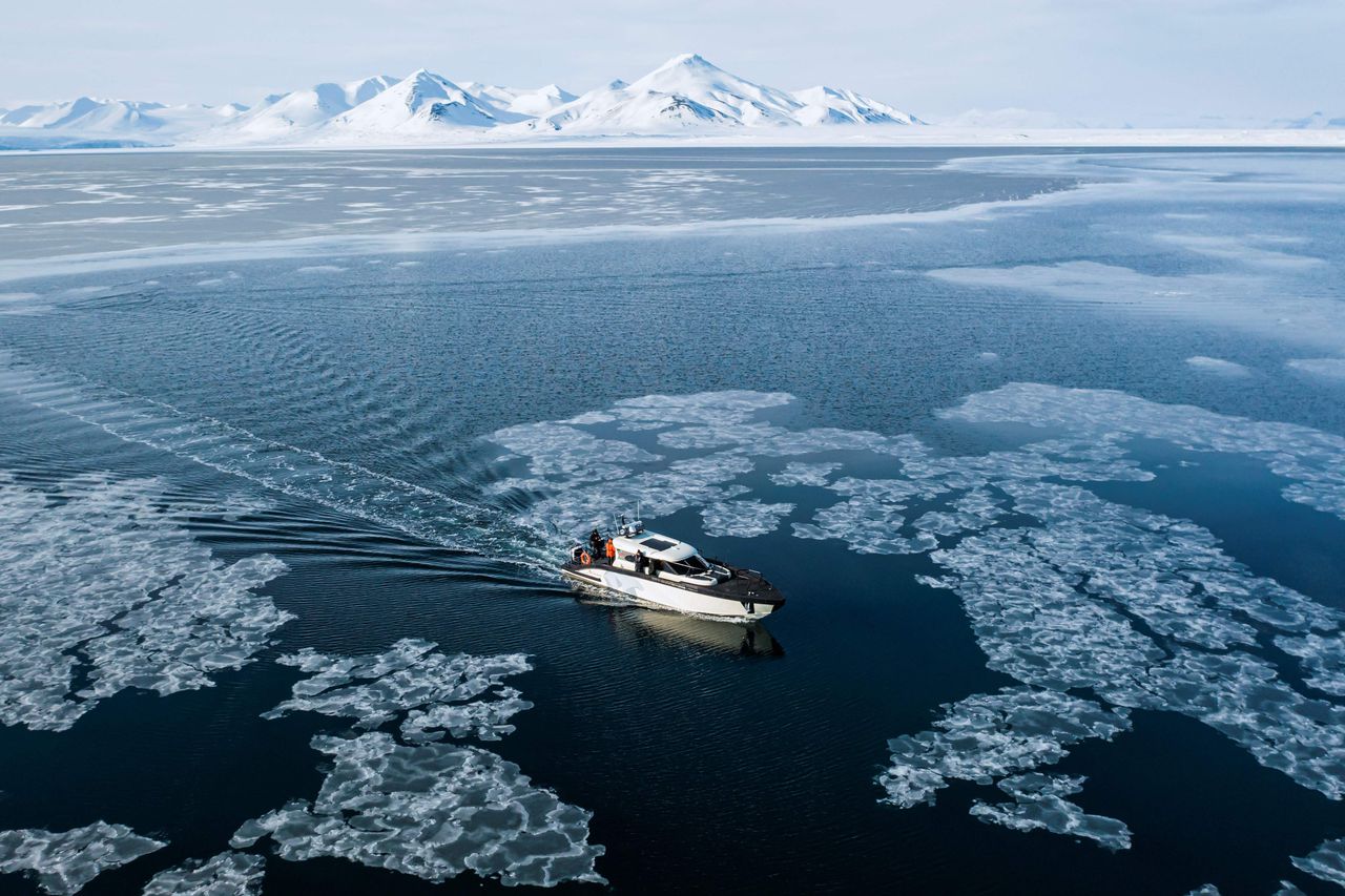 Een hybride schip vaart door de ijsschotsen in Borebukta, een baai aan de westelijke kant van de Noorse eilandengroep Spitsbergen.