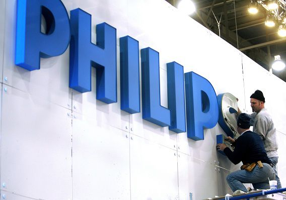 Workers put up a sign at the Philips Electronics booth before the Consumer Electronics Show (CES) at the Las Vegas Convention Center in this January 3, 2008 file photo. Philips is hiving off its once leading television business, the first step by new chief executive Frans van Houten to boost flagging profit at Europe's biggest consumer electronics maker. Philips is moving its loss-making TV business to a 30/70 joint venture with Hong-Kong based monitor maker TPV and has the option to sell out. The Dutch group has struggled to compete against players like Samsung and LG Electronics. Van Houten, a restructuring expert who took over as CEO this month, said on April 18, 2011 he is assessing the profitability of Philips' 400 or so business areas, a hint that further divestments could be on the cards. REUTERS/Las Vegas Sun/Steve Marcus/Files (UNITED STATES - Tags: SOCIETY BUSINESS)