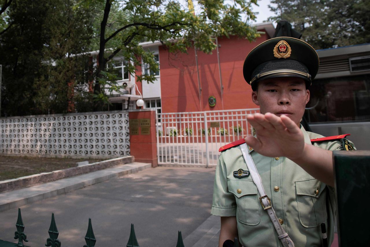 Een agent voor de toegang van de Belgische ambassade in Beijing. Hier werd in juni een Oeigoerse familie meegenomen door de Chinese politie.