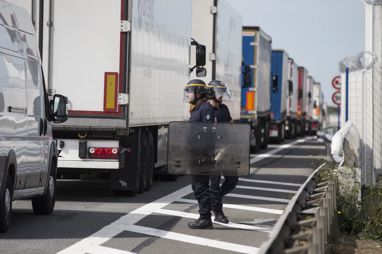 De Franse politie bewaakt stilstaande vrachtwagens bij Calais.