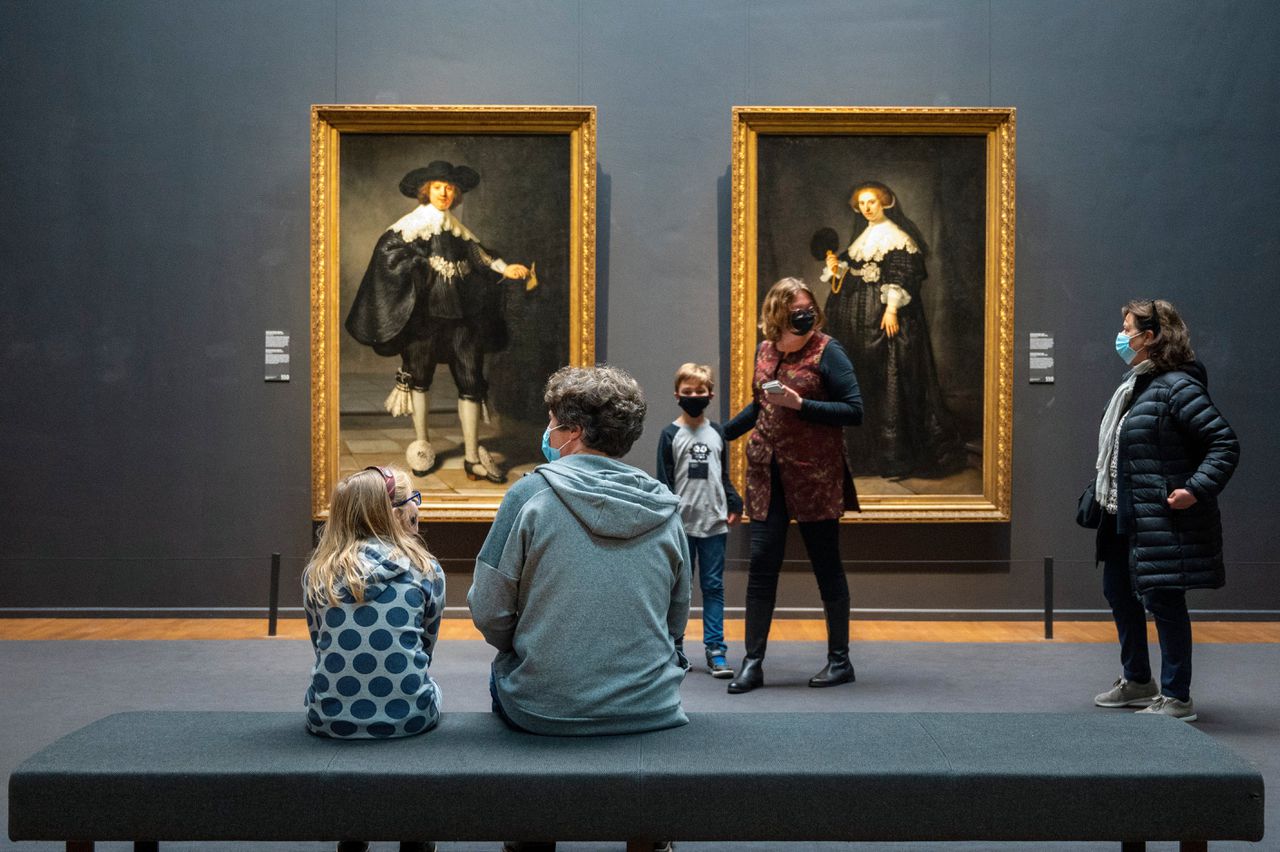 Bezoekers in het Rijksmuseum bij Rembrandts portretten van Marten Soolmans en Oopjen Coppit .