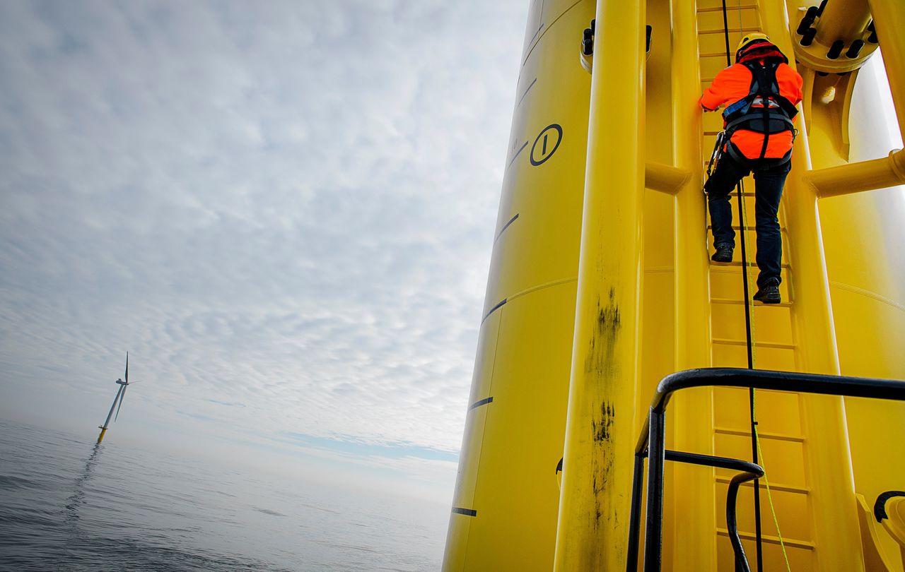 Een medewerker van Eneco klimt in een windmolen van windpark Luchterduinen voor de kust van Noordwijk.