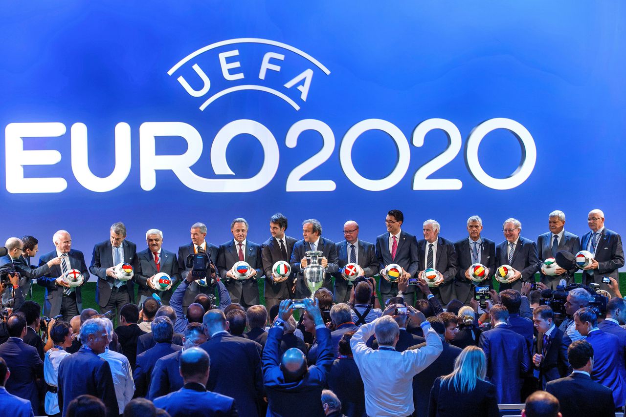 Vertegenwoordigers van de speelsteden van het oorspronkelijke EK poseren met toenmalig UEFA-voorzitter Michel Platini (midden) in Genève, in september 2014.