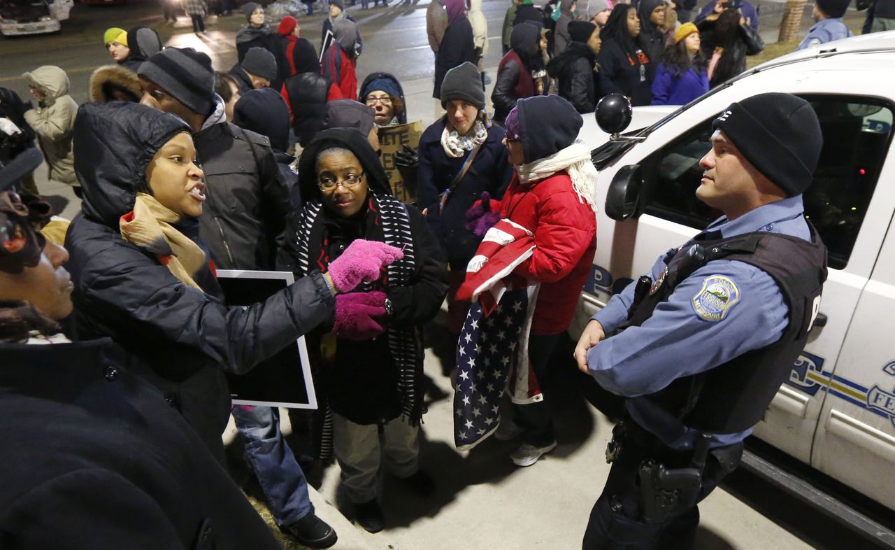 Demonstranten discussiëren met een agent in Ferguson nadat gisteren het rapport over raciale misstanden in de voorstad van St. Louis in de staat Missouri openbaar werd gemaakt.