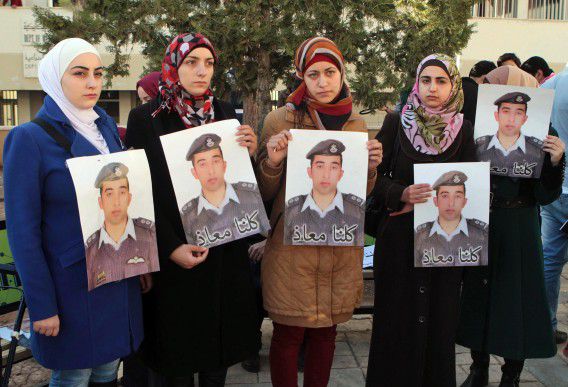 Jordaanse vrouwen poseren met de foto van Al-Kaseasbeh. De derde van links is zijn echtgenote.