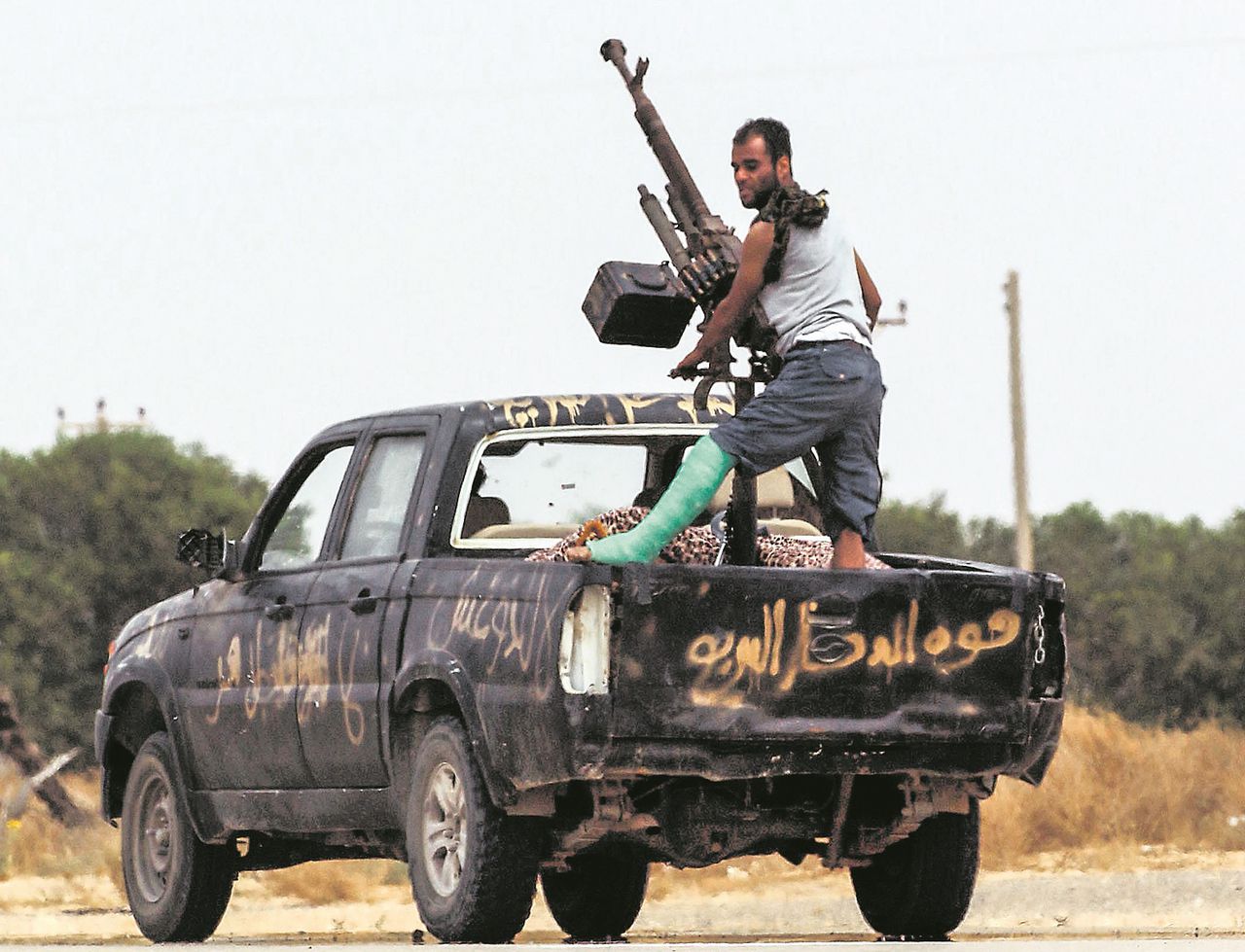 Een strijder voor de eenheidsregering vecht door met zijn been in het gips, bij Sirte.