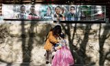 Een moeder en dochter staan in de Zuid-Koreaanse hoofdstad bij affiches voor de verkiezingen van woensdag. 
