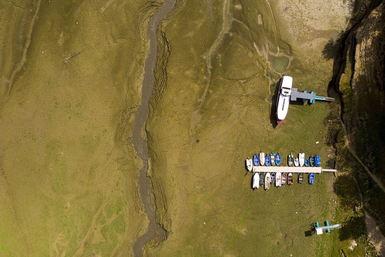 Boten op een uitgedroogde rivier bij de grens tussen Frankrijk en Zwitserland. Door de aanhoudende droogte zakte het waterpeil er deze zomer drastisch.