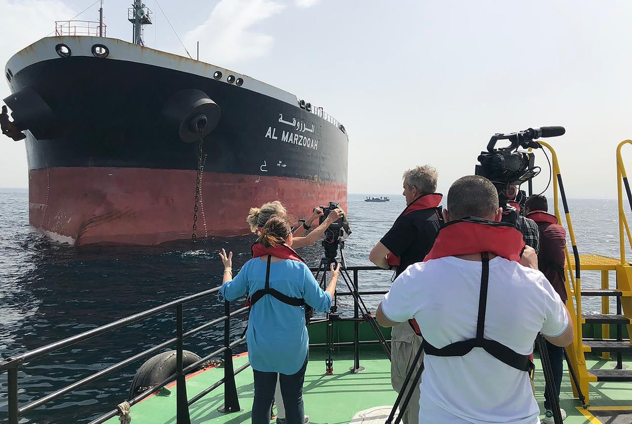 Journalisten filmen beelden van de olietanker Al-Marzoqah, een van de vier commerciële schepen die volgens de Verenigde Arabische Emiraten werden getroffen door een 'sabotage-aanval'.