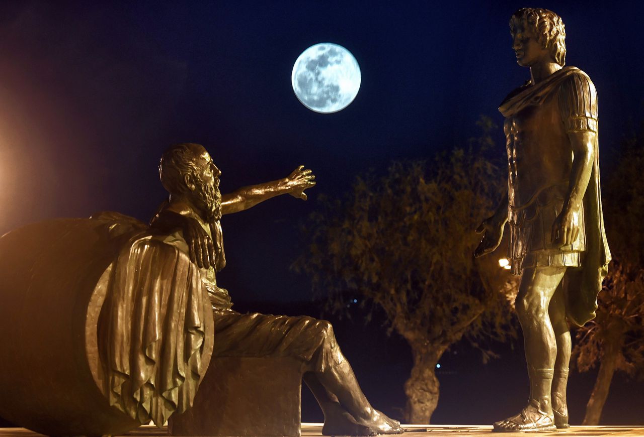 Stanbeelden van Diogenes en Alexander de Grote bij maanlicht in Korinthe, Griekenland