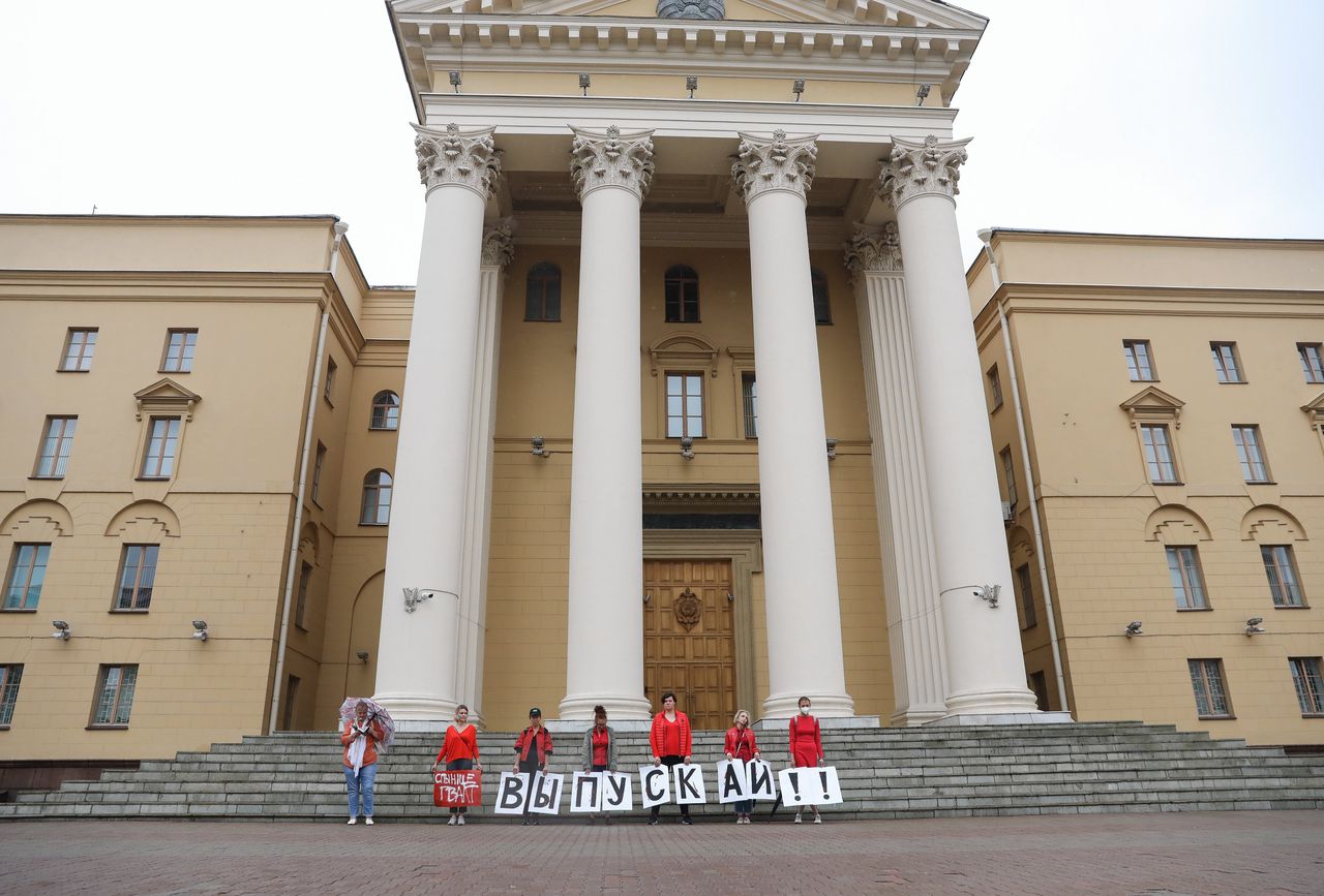 Voor het gebouw van de Wit-Russische geheime dienst KGB in Minsk houden Wit-Russische vrouwen letters omhoog die samen de tekst ‘Laat hen vrij!’ vormen. Duizenden demonstranten werden de afgelopen maanden door het Wit-Russische regime opgepakt.