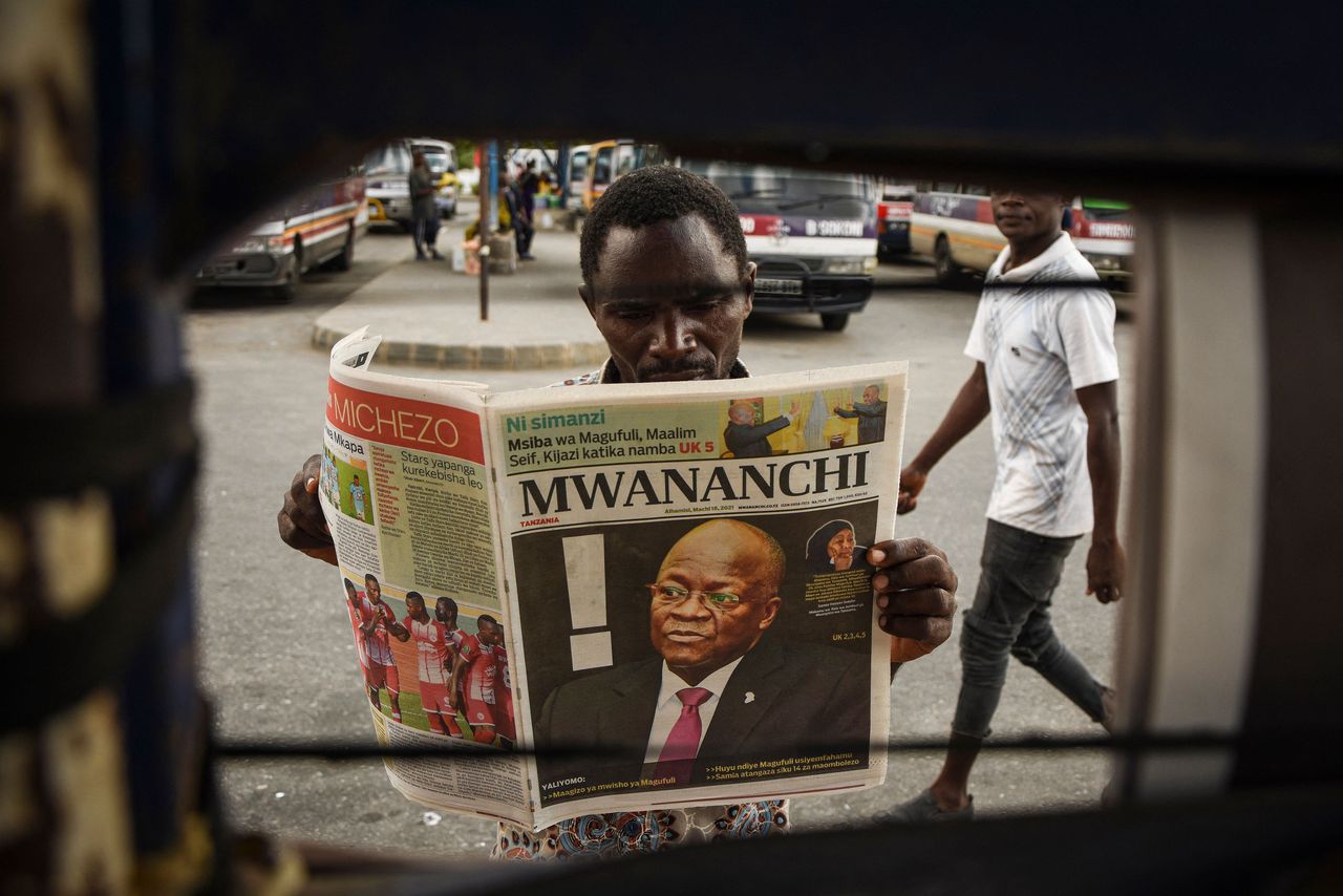 Een Tanzaniaanse man leest in Dar es Salaam de krant met daarin het bericht van het overlijden van president John Magufuli