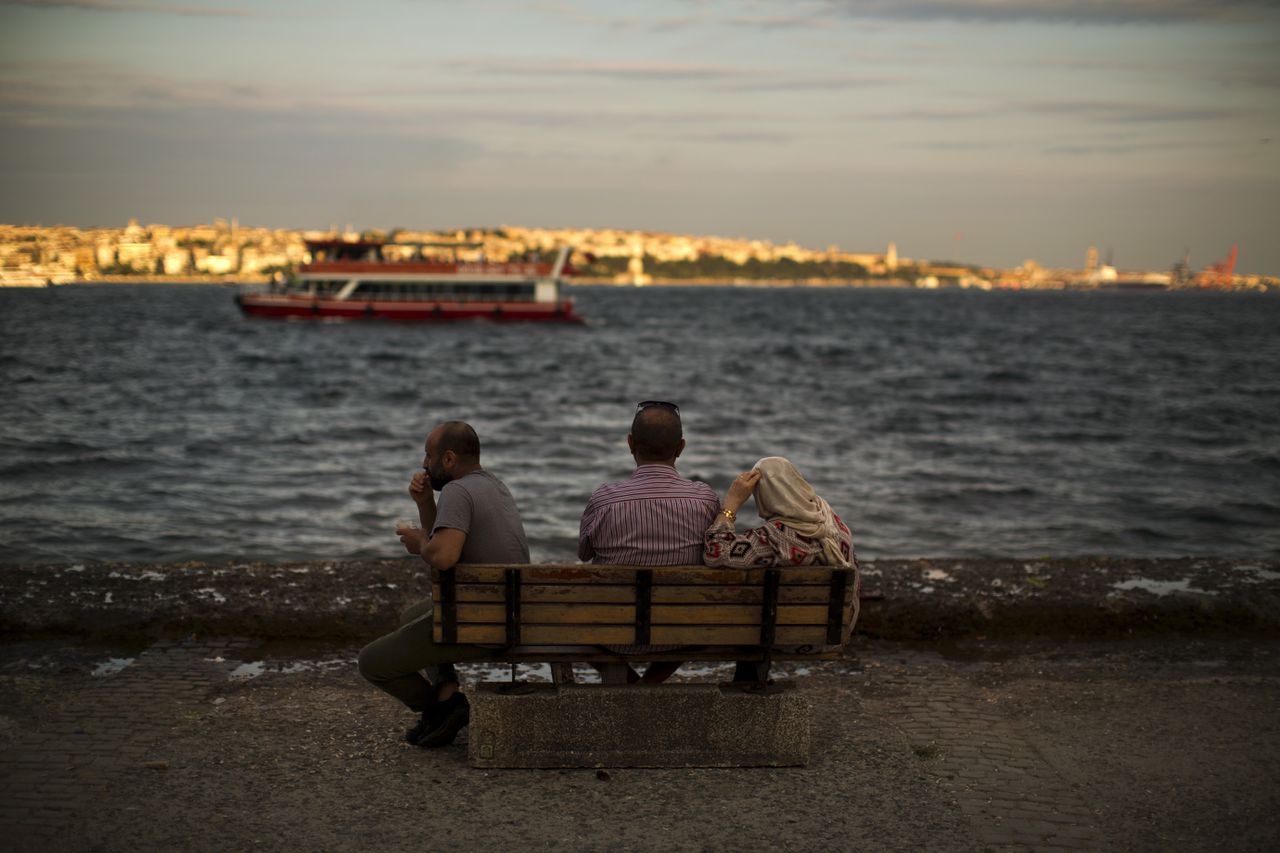 Drie mensen kijken maandag uit over de Bosporus, Istanbul.