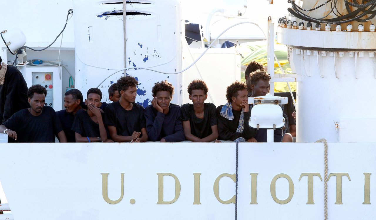 Migranten wachten in de haven van de Siciliaanse stad Catania op reddingsschip Diciotti om van boord te mogen.