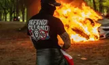 Een demonstrant bij een brandende politieauto. Foto Hedayatullah Amid 