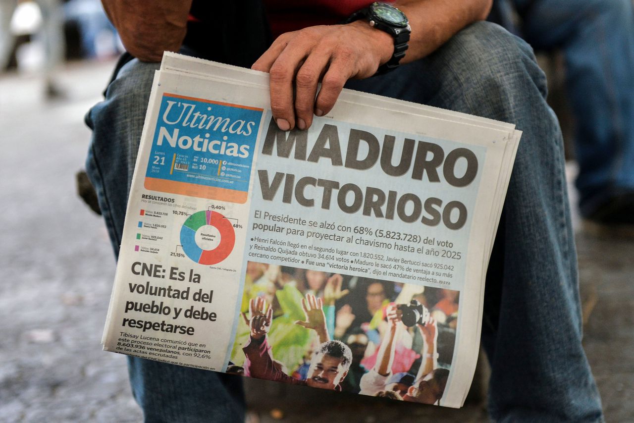 Een man houdt een Venezolaanse krant vast die bericht over de verkiezingszege van Maduro.