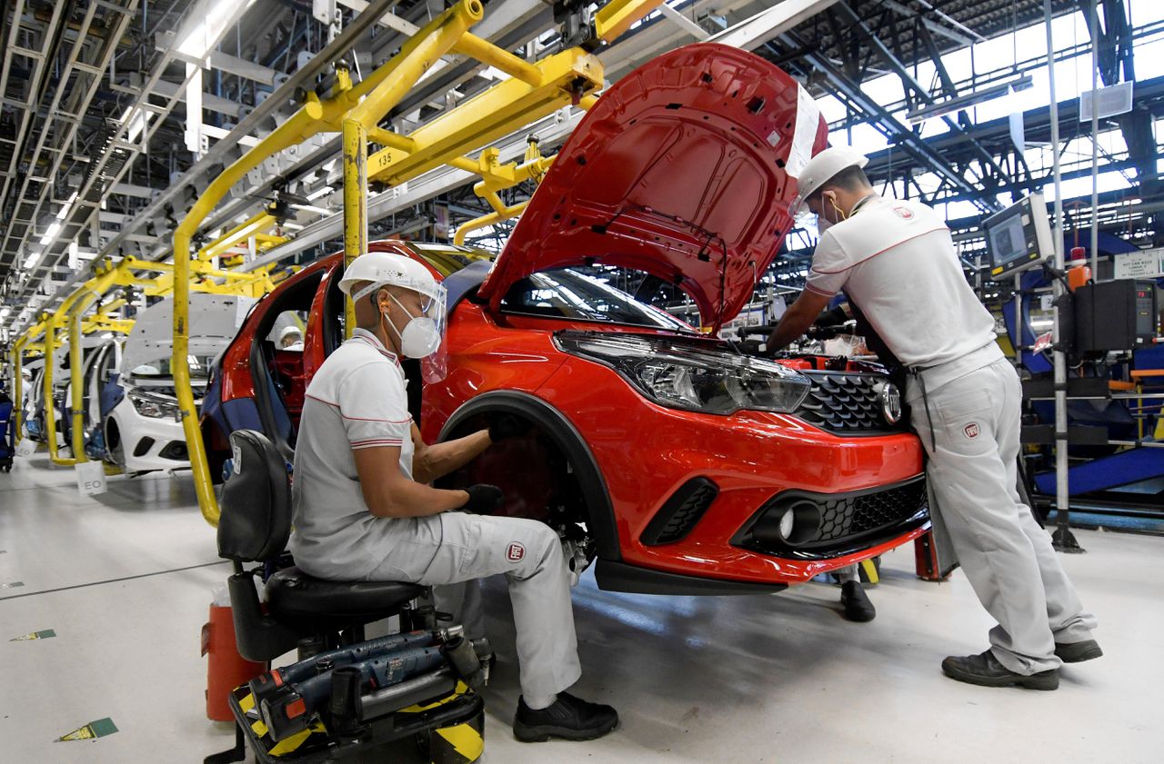 Medewerkers van Fiat Chrysler Automobiles sleutelen aan een auto in een fabriek in Brazilië.