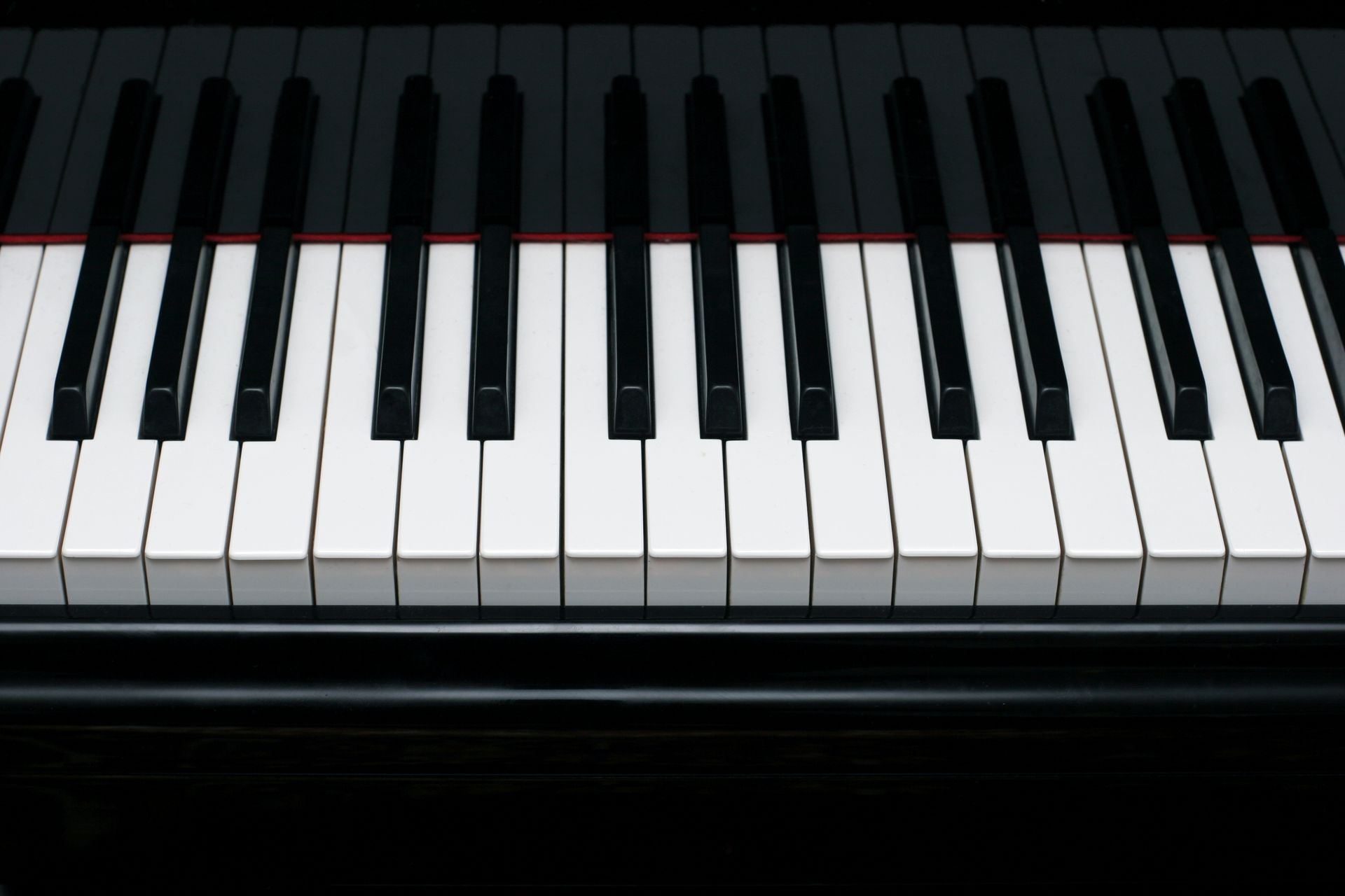 Close-up of a shiny grand piano ebony and ivory keys. 