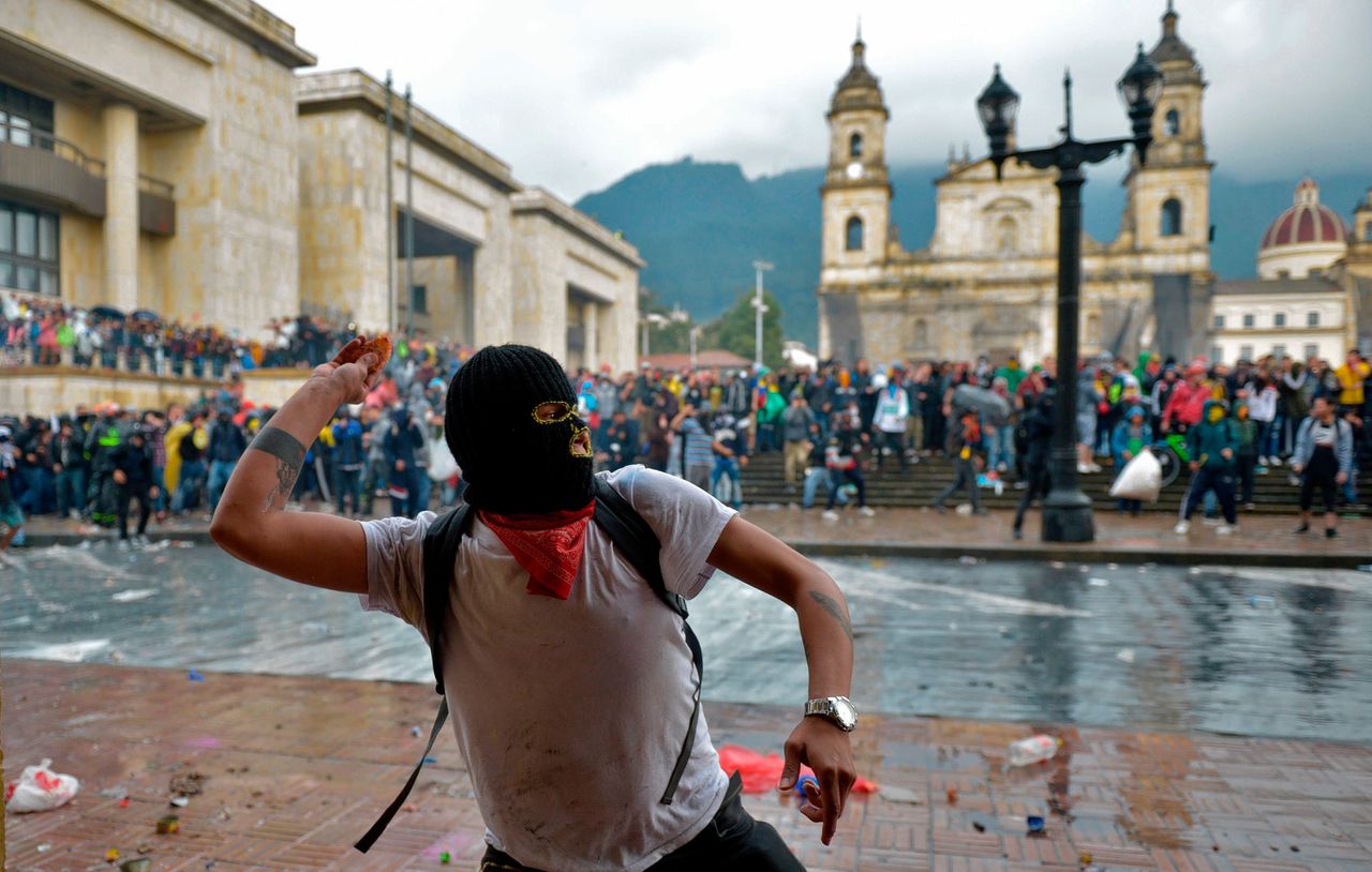 Een demonstrant gooit een steen naar de oproerpolitie tijdens protesten in de Colombiaanse hoofdstad Bogotá.