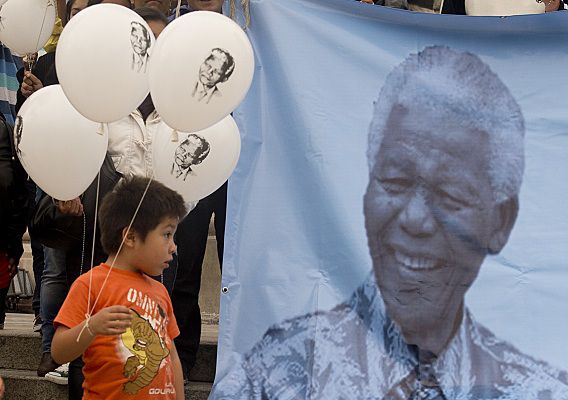 Een jongetje houdt ballonnen vast met de afbeelding van de voormalige Zuid-Afrikaanse president Nelson Mandela, tijdens de Internationale Mandela Dag 18 juli in New Mexico.
