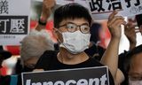 Joshua Wong tijdens een protest in september bij zijn eigen proces in Hongkong. Hij kreeg woensdag samen met twee medeactivisten celstraffen opgelegd.