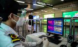 Een Chinese beveiliger bekijkt warmtecamera’s die koorts meten van metroreizigers om patiënten met het coronavirus te herkennen. De camera’s maken gebruik van 5G-technologie.