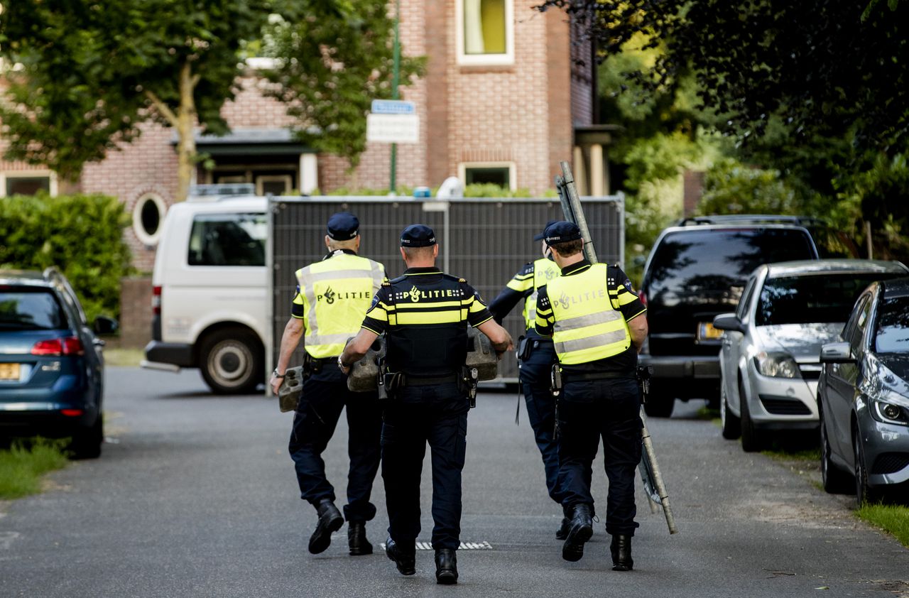 Agenten verplaatsen hekken bij het huis van Koen Everink voorafgaand aan de reconstructie van de moord op de zakenman.
