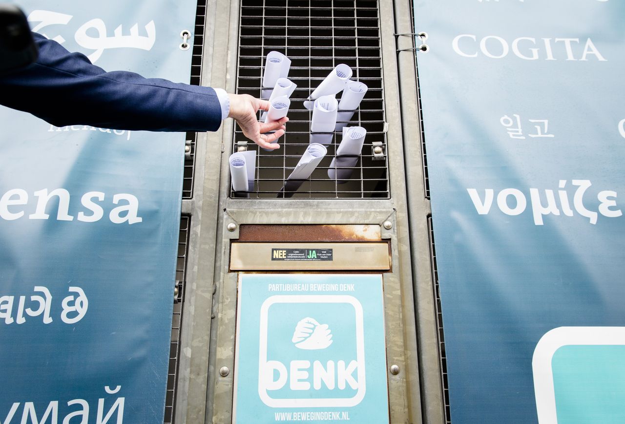 Medewerkers van Denk stoppen briefjes door het hek van het partijbureau met een verklaring van kamerlid Selcuk Öztürk, over het integriteitsonderzoek dat naar hem is gestart.