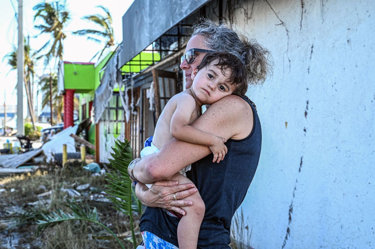 Een vrouw met haar zoon buiten haar huis in Florida.