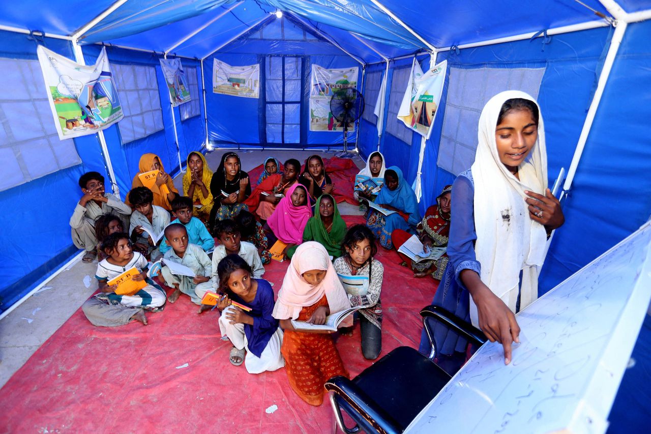 Kinderen die door de overstromingen in Pakistan ontheemd zijn geraakt, krijgen les in een geïmproviseerd schooltje in een tent in de stad Hyderabad. Veel schoolgebouwen worden nu juist gebruikt om vluchtelingen op te vangen.