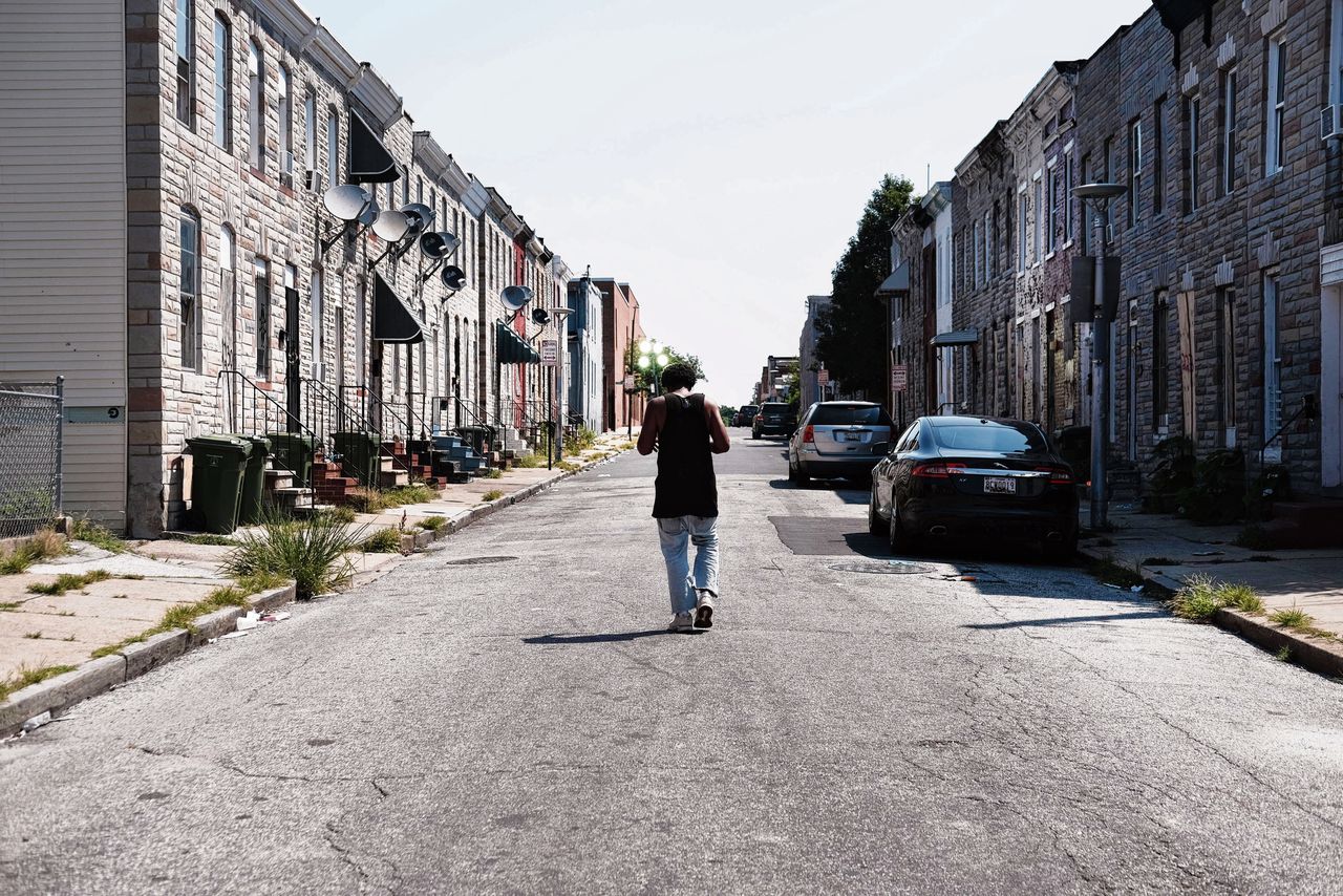 Een man in een straat in Baltimore. De stad ligt in het district dat door Trump „walgelijk” genoemd werd.