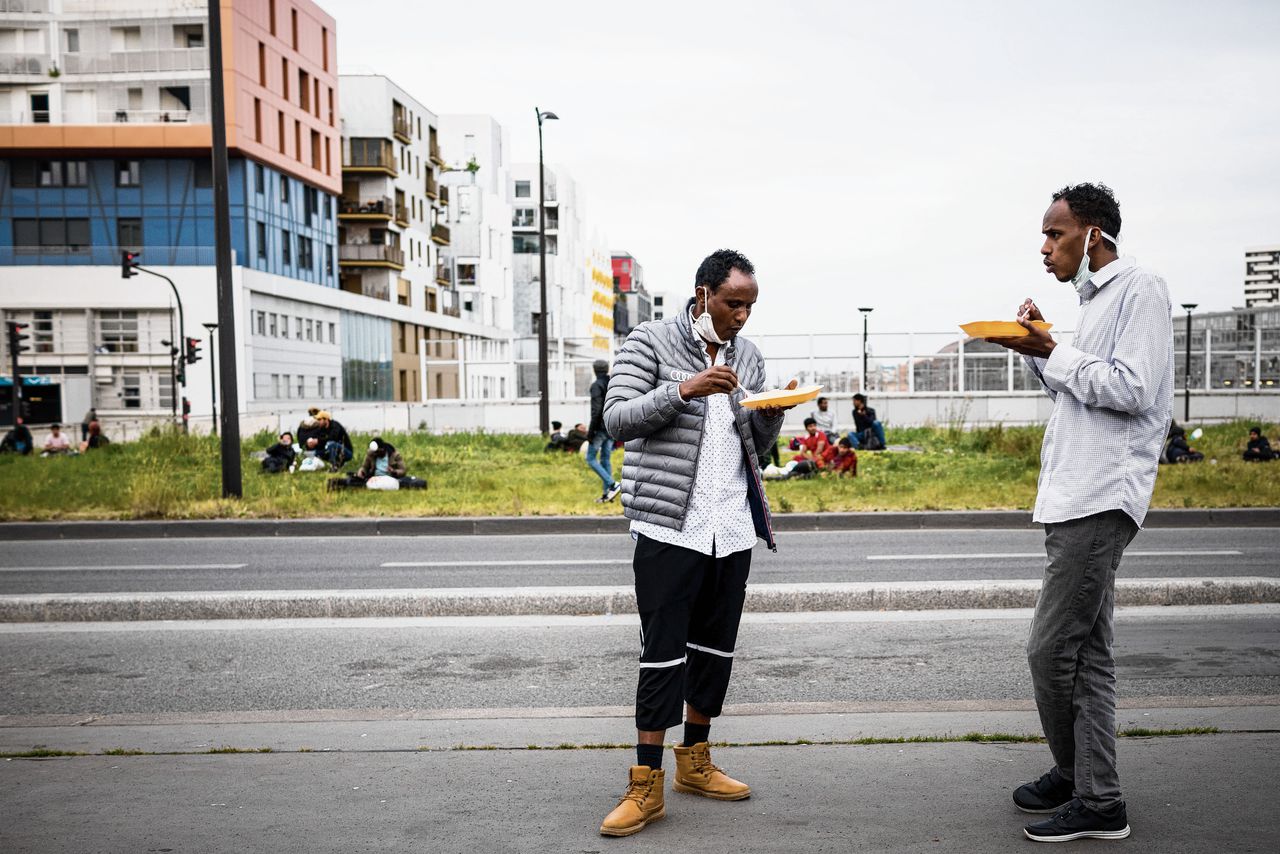 Bij Porte d’Aubervilliers, aan de rand van Parijs, delen hulpverleners van organisatie Solidarité Migrants Wilson water en eten uit aan mensen in de buurt, van wie er velen veelal dakloos zijn.