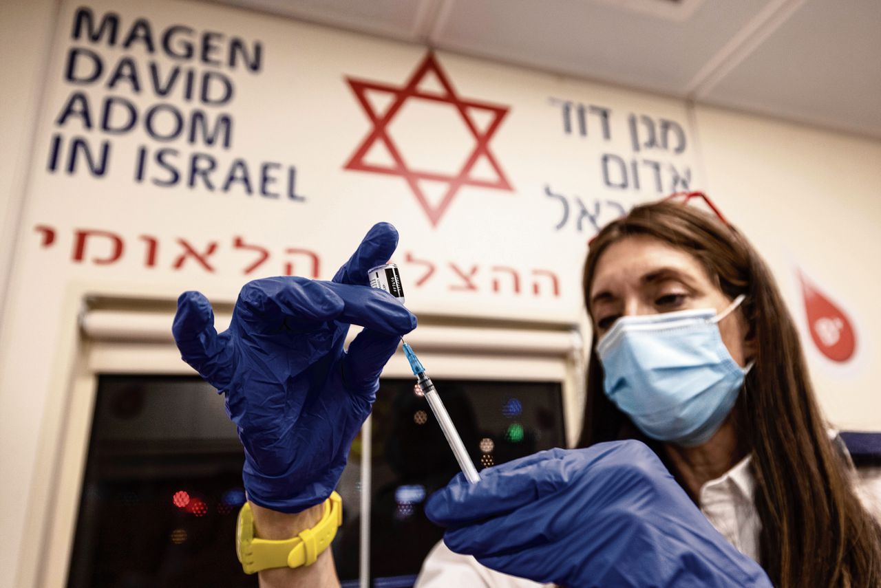 Boostervaccinatie bij de ambulancedienst in Tel Aviv. Herhaalvaccinaties werken ook tegen nieuwe besmettingen. Foto Tsafrir Abayov/AP