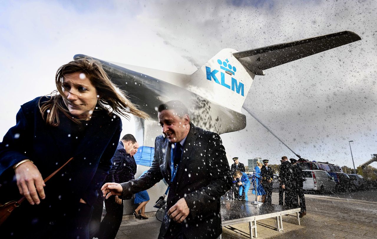 KLM-personeel schuilt achter het nog te openen Fokkermonument bij het afscheid, zondag, van de laatste Fokkertoestellen op Schiphol.