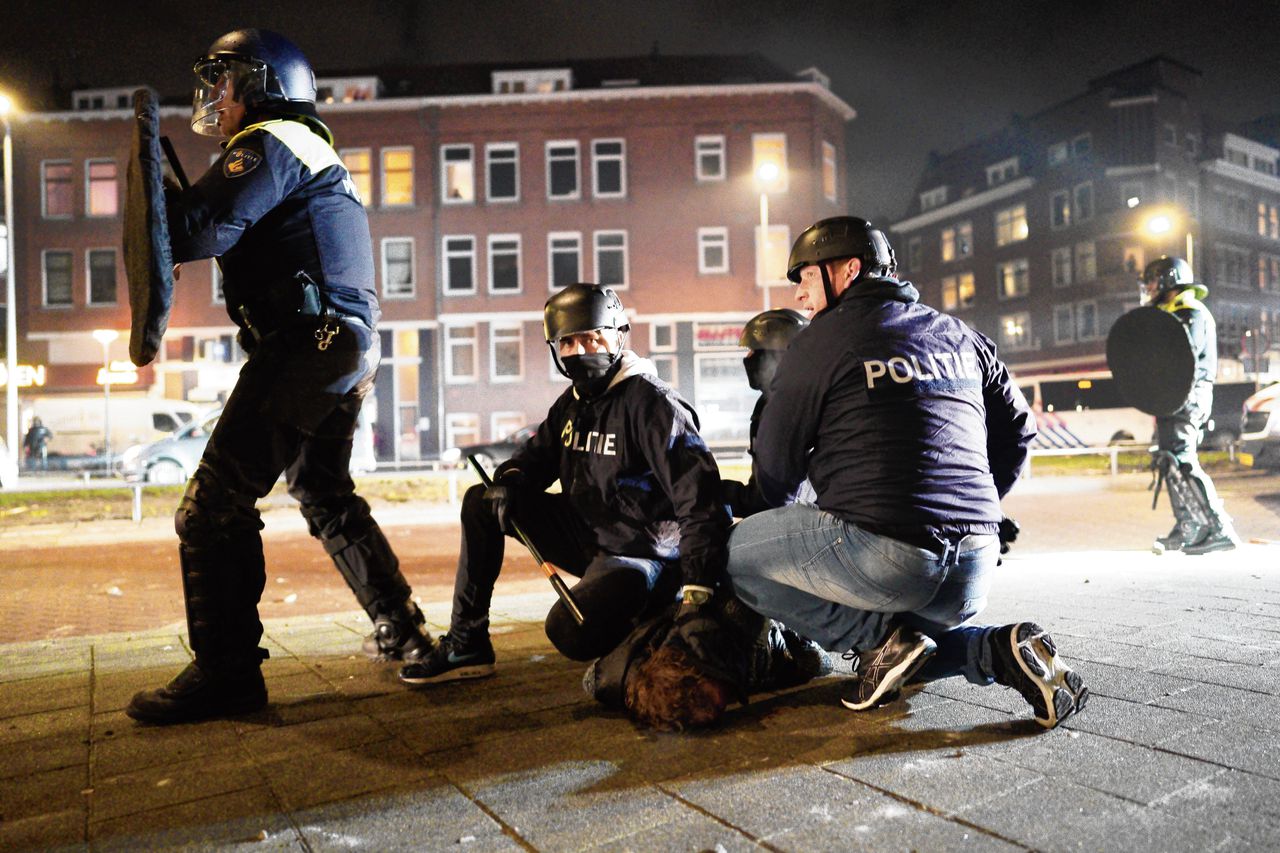 De politie houdt een relschopper aan in Rotterdam, maandagavond.