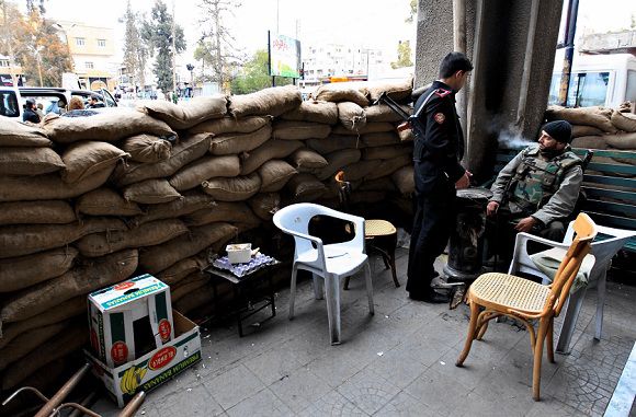 Caption: A Syrian policeman and a soldier stand guard outside a police station in the southern Syrian city of Deraa January 22, 2012. REUTERS/Ahmed Jadallah (SYRIA - Tags: POLITICS CIVIL UNREST)