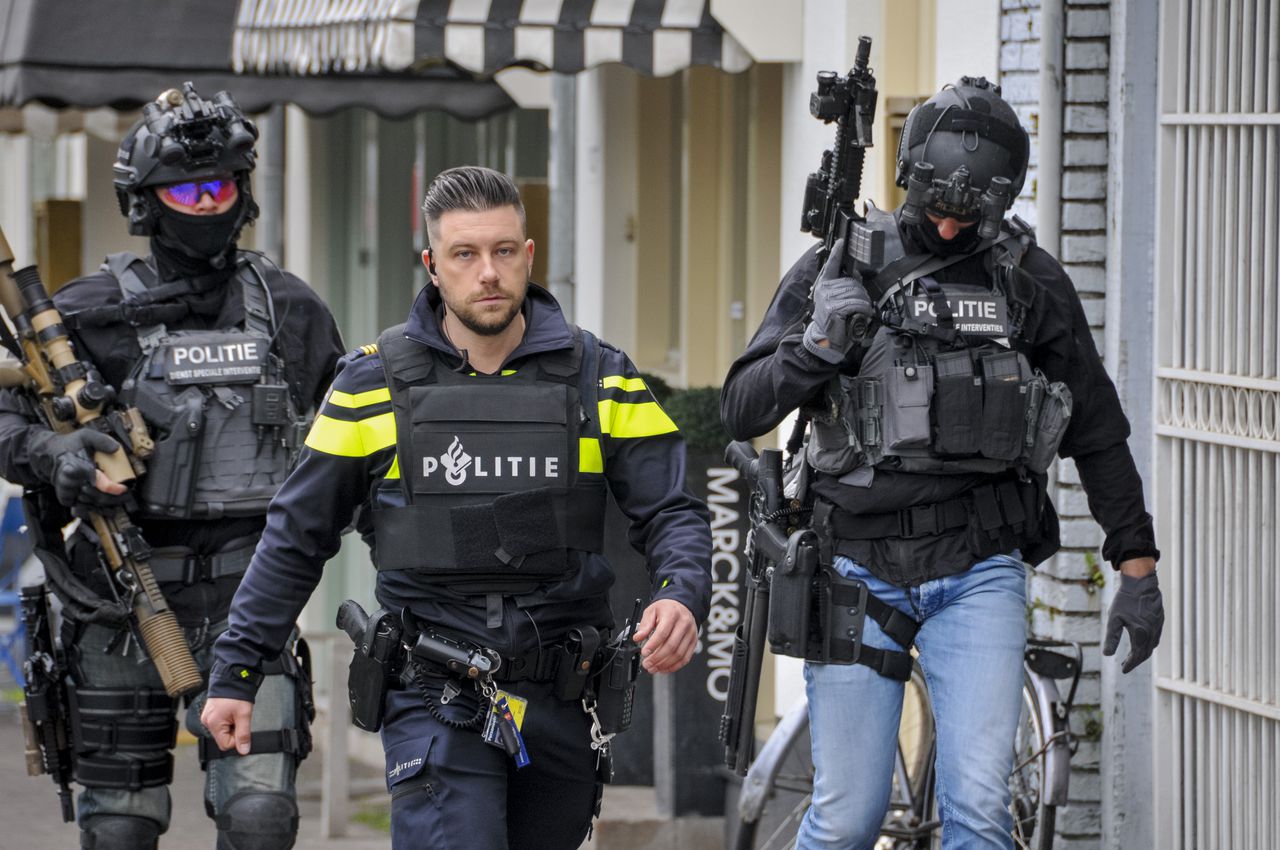Een politieagent en twee medewerkers van de DSI in de Arnhemse wijk Klarendal.