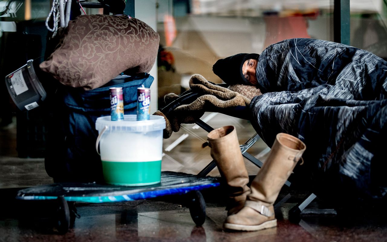 Een dakloze voorafgaand aan een demonstratie, op de stoep voor de Stopera in Amsterdam.